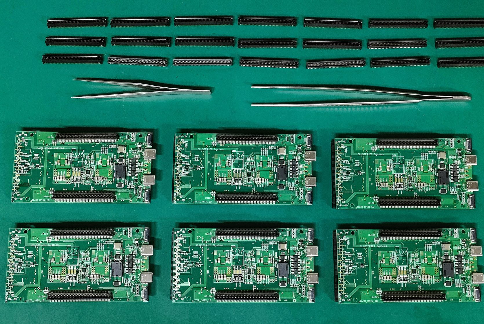 Individuelle Prototypen-Fertigung Sechs grüne Leiterplatten und einige schwarze Stiftleisten auf einer ESD-Schutzmatte.